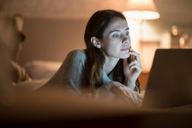 istock Bed laptop evening woman 1191442092