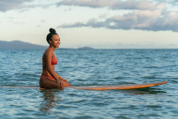 istock Young woman sitting on her surfboard waiting for a wave 1191442296
