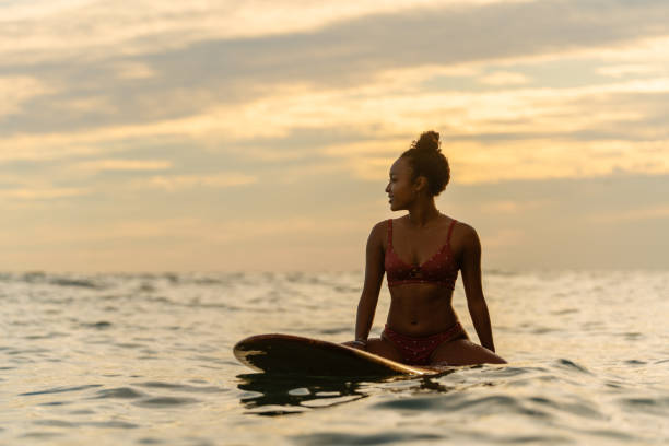 istock Young woman sitting on her surfboard waiting for a wave 1191442299