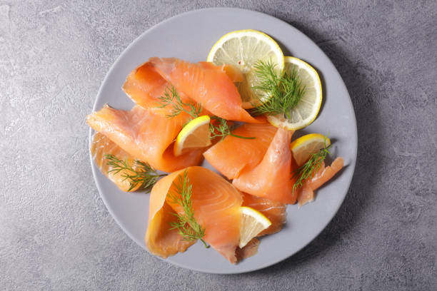 smoked salmon with lemon and dill, top view smoked salmon with lemon and dill, top view smoked salmon stock pictures, royalty-free photos & images