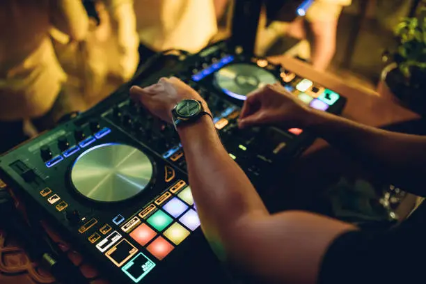 Dj mixer playing music in the nightclub.