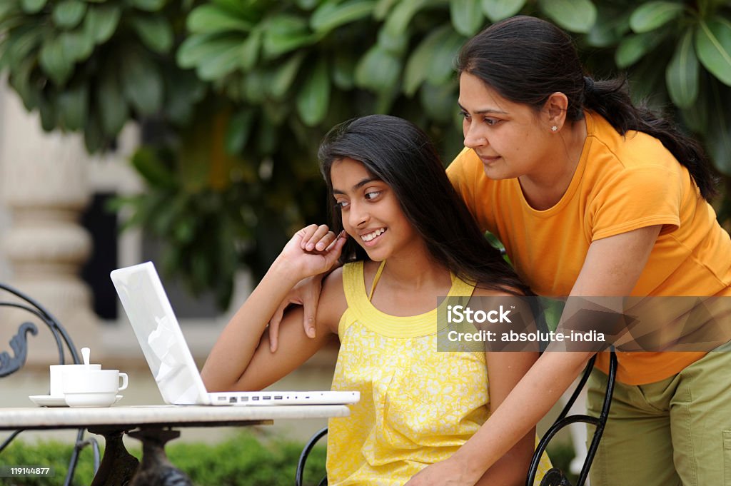 Amorevole Madre e figlia con portatile in spazi aperti - Foto stock royalty-free di Adolescente