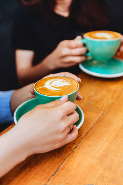 istock two beautiful woman keeping cups of coffee. 1191450161
