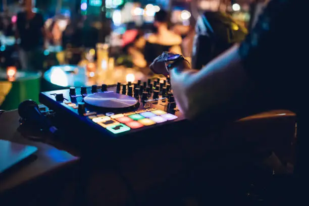 Dj mixer playing music in the nightclub.