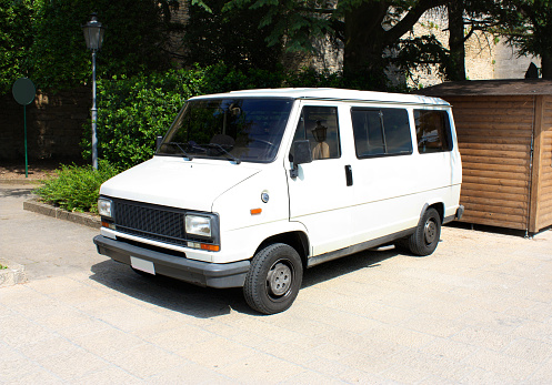 White vintage van is parked on pavement next to the wooden booth