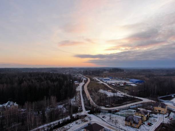 istock Aerial view green field surrounded by forest covered with white snow. Beautiful panoramic landscape of nature 1191451652
