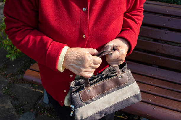 Elderly woman holding a bag.