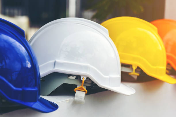 istock White, yellow and other colored safety helmets for workers' safety projects in the position of engineers or workers on concrete walls in the city. 1191452070