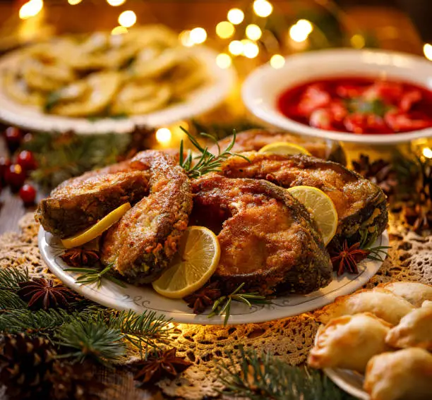 Christmas carp, Fried carp fish slices on a white plate  on a holiday table, close up. Traditional christmas eve dish. Polish Christmas