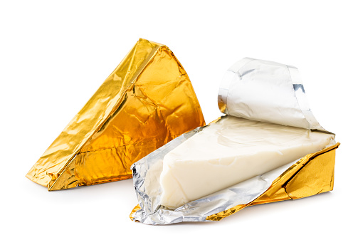 Cheese triangle in foil unpacked close-up on a white background. Isolated