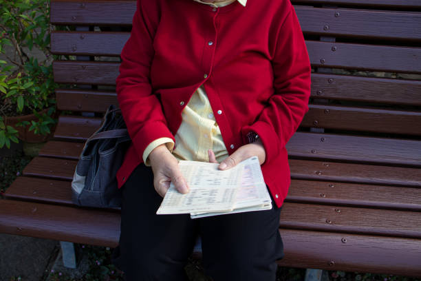 Elderly woman looking at passbook.