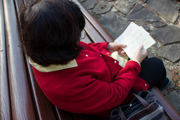 Elderly woman looking at passbook.