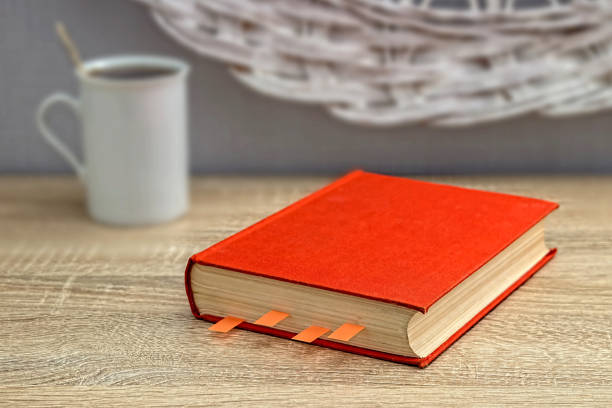 istock White cup of tea and a book on a wooden table. Reading, learning 1191454322