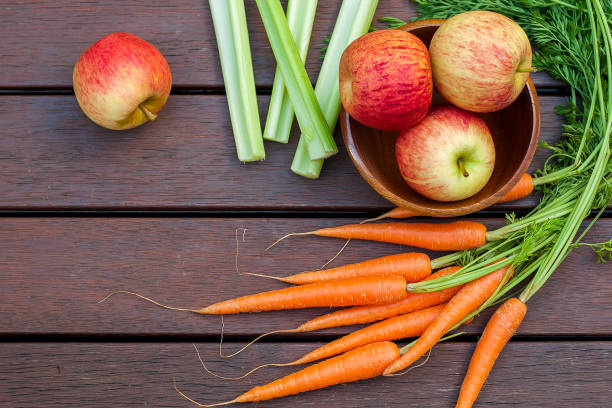 istock Carrots, apples and celery on the wood 1191457563