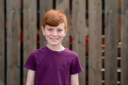 A portrait of a boy smiling while looking at the camera.