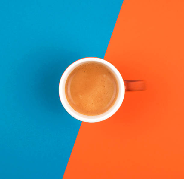 istock Fresh brewed coffee in ceramic cup over orange and blue background.  Place for text. 1191460438