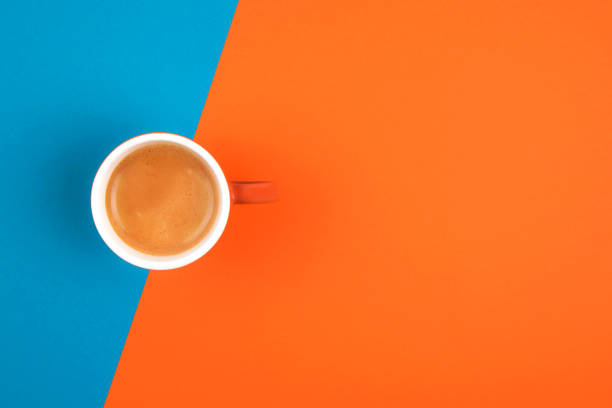 istock Fresh brewed coffee in ceramic cup over orange and blue background.  Place for text. 1191460443