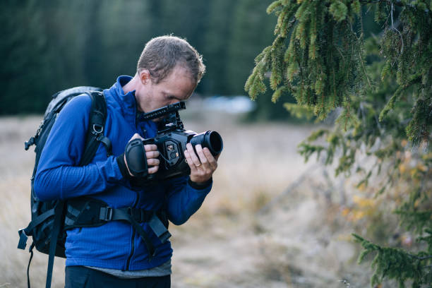 istock Young man films nature scene in forest 1191460905