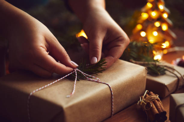 istock Closeup of woman's hands while wrapping Christmas presents 1191461146