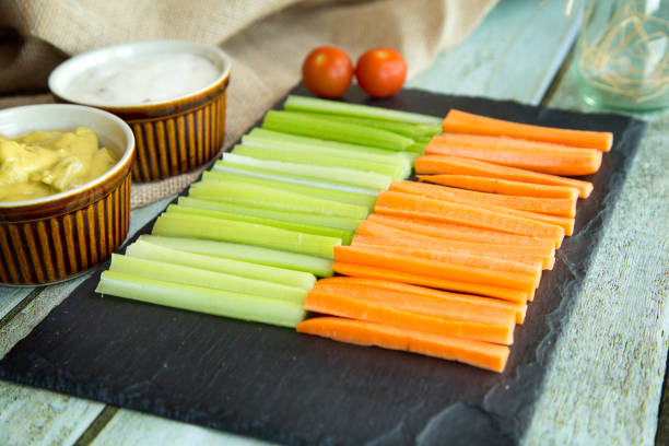 istock Fresh vegan sticks vegetables white and green sauce on black stone background, selective focus 1191463391
