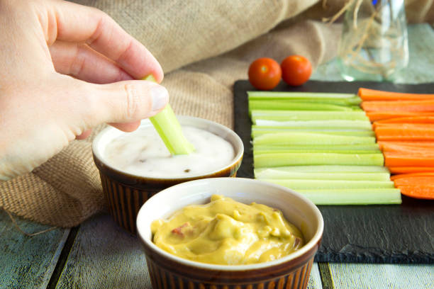 istock Fresh vegan sticks vegetables white and green sauce on black stone background, selective focus 1191463671