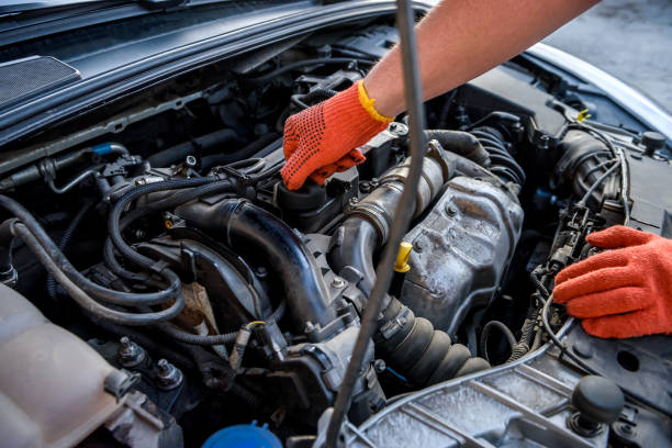 istock Hands in protective gloves with car engine close up. Car repair concept 1191465486
