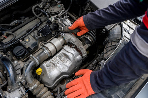 istock Hands of mechanic's in protective gloves with car engine close up 1191466636