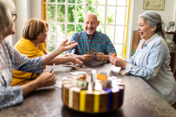 istock Joyful elderly people having fun with cards 1191468620
