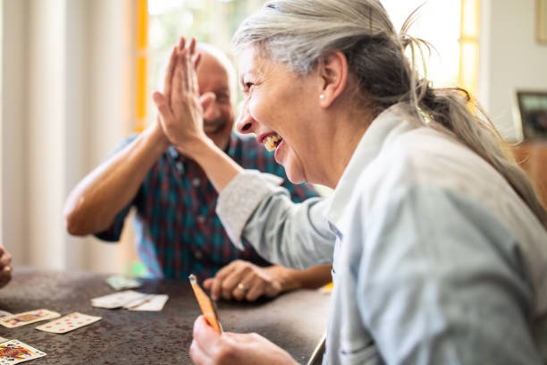 High five for that move Argentinian elderly woman and man doing high-five during game with cards at home friends playing cards stock pictures, royalty-free photos & images