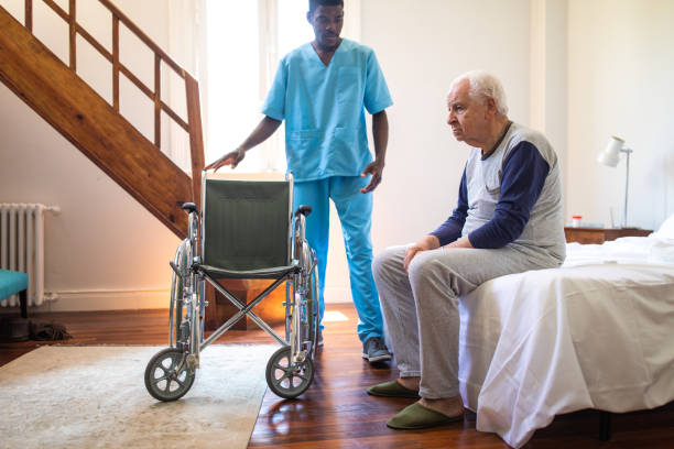 istock Physical therapist helping old man on bed 1191469039