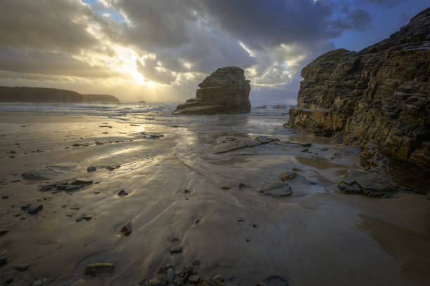 istock Sun rays of sunset seeps through the clouds on a beach 1191477743