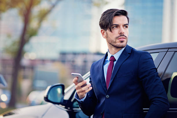 istock Businessman is texting next to his car 1191481800