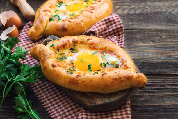 Fresh homemade khachapuri Ajarian on rustic wooden background Dough boats filled with sulguni cheese and egg. Traditional Georgian cuisine. 777 stock pictures, royalty-free photos & images