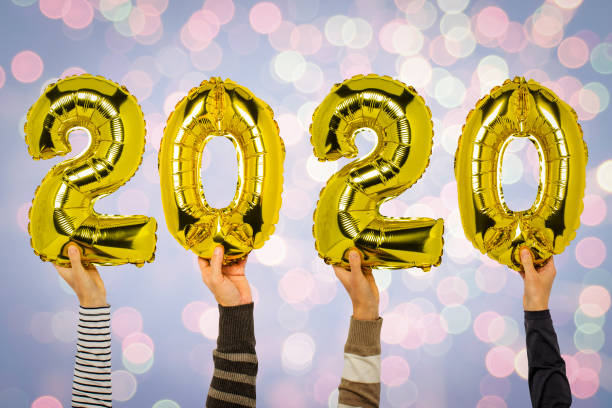 istock Hands holding balloons 2020 numbers on a background with a festive firework. Concept new year, the onset of 2020, the year of the white rat 1191487314