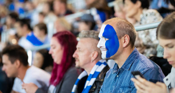 istock Cheering Fans With Blue Banging Thundersticks 1191488445