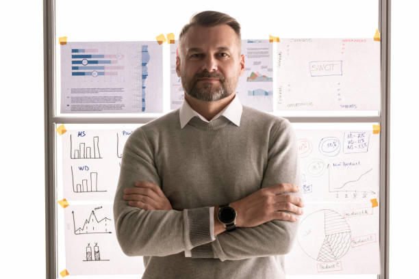 istock Casual mature businessman standing against whiteboard with documents 1191494183