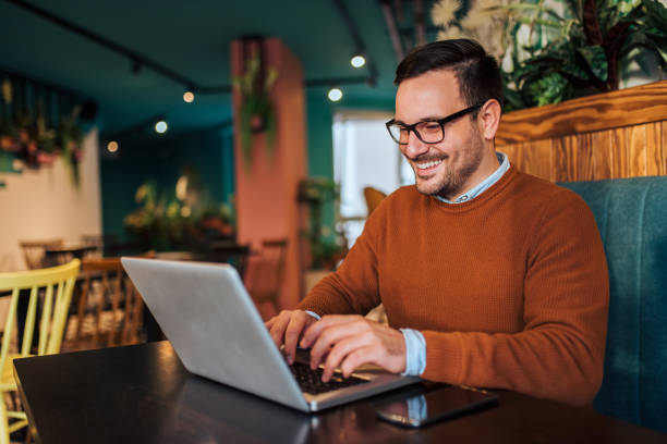 istock Cheerful freelancer working on laptop in the cafe, portrait. 1191497314