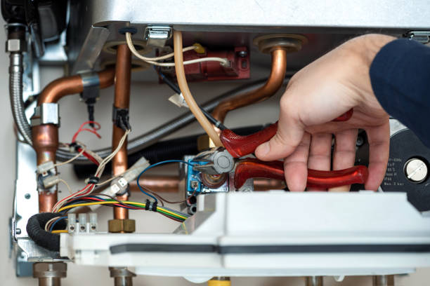 istock Technician repairing the combi gas boiler with wire cutter in hand 1191497601