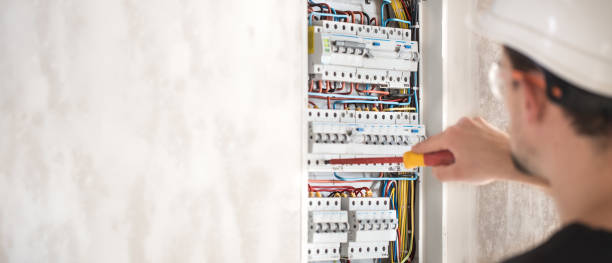 homem, um técnico elétrico que trabalha em uma central telefônica com fusíveis. instalação e conexão de equipamentos elétricos. - electricity control panel engineer electronics industry - fotografias e filmes do acervo