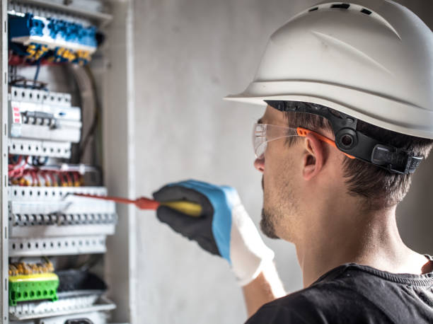istock Man, an electrical technician working in a switchboard with fuses. Installation and connection of electrical equipment. 1191500883