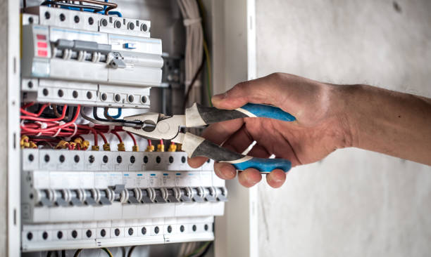 istock Man, an electrical technician working in a switchboard with fuses. Installation and connection of electrical equipment. Close up. 1191500900