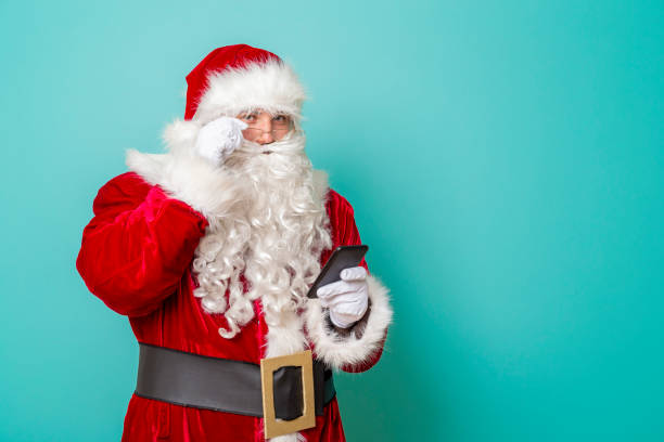 istock Santa Claus typing a text message on a smartphone 1191501254