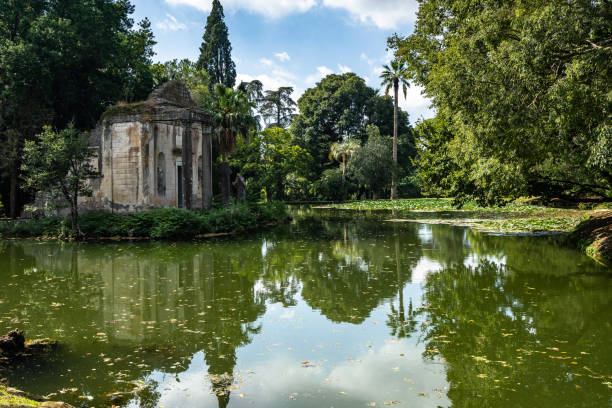 l'étang du jardin anglais du palais royal de caserta. au milieu, il ya une petite île avec de fausses ruines d'un temple - gate palace english culture formal garden photos et images de collection