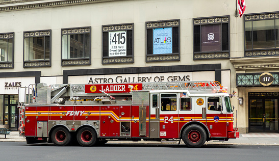 New York, USA. Big red fire truck with ladder in the streets of the town