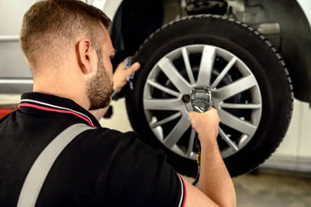 Photo of Car mechanic is changing tire