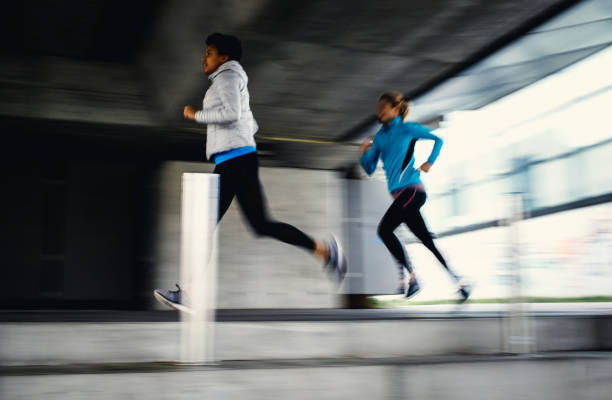 istock Two Female Athletes Running Outdoors, Blurred Motion 1191505902