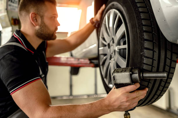 istock Car mechanic is changing tire 1191506017