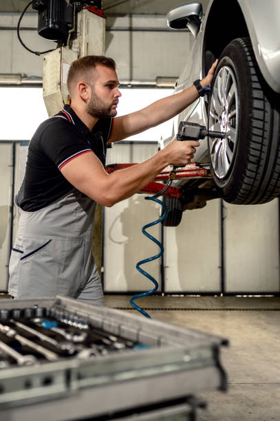 istock Car mechanic is changing tire 1191508162