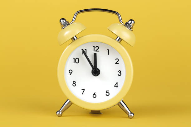 istock Yellow round alarm clock on the yellow background. 1191508575