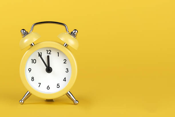 istock Yellow round alarm clock on the yellow background. 1191508579